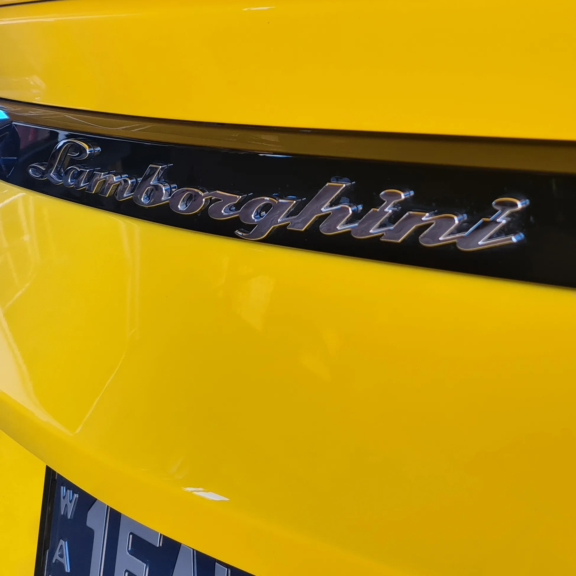 Close-up of yellow Lamborghini rear badge and paintwork after professional detailing by Kimberley Auto Care