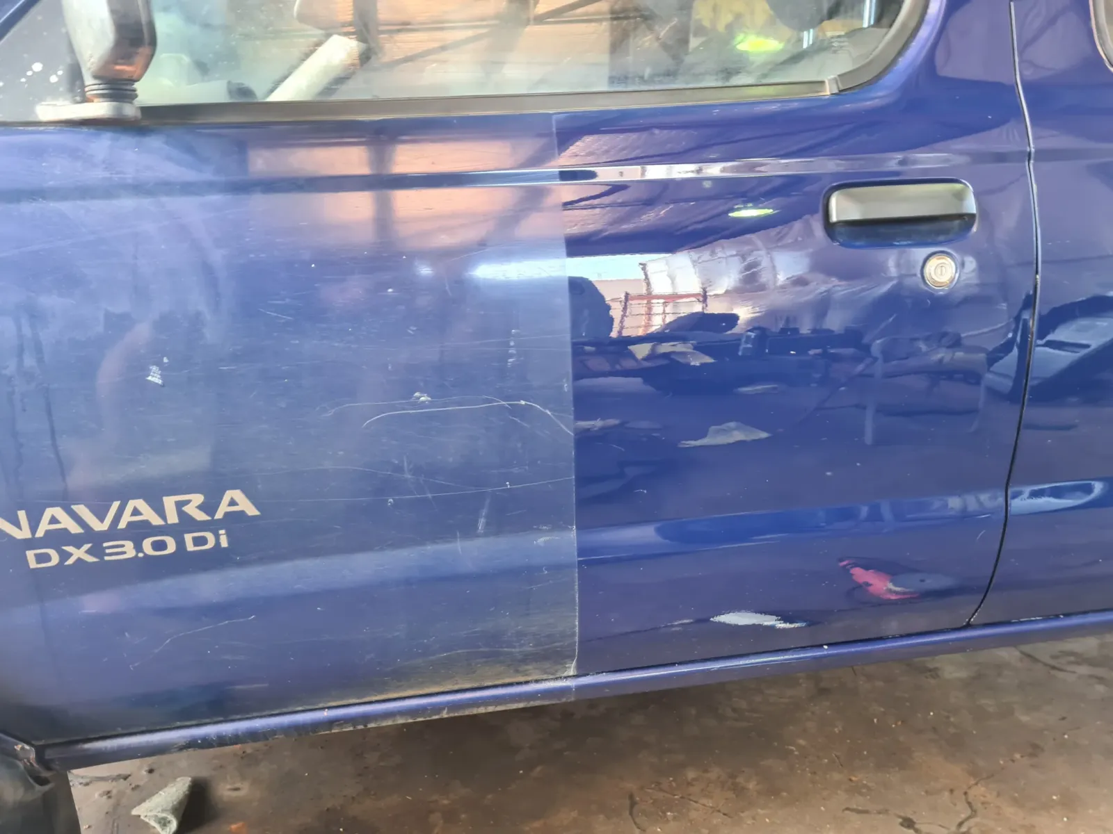 Before and after cut and polish on blue Nissan Navara DX 3.0 Di showing scratched dull paint restored to high-gloss finish by Kimberley Auto Care