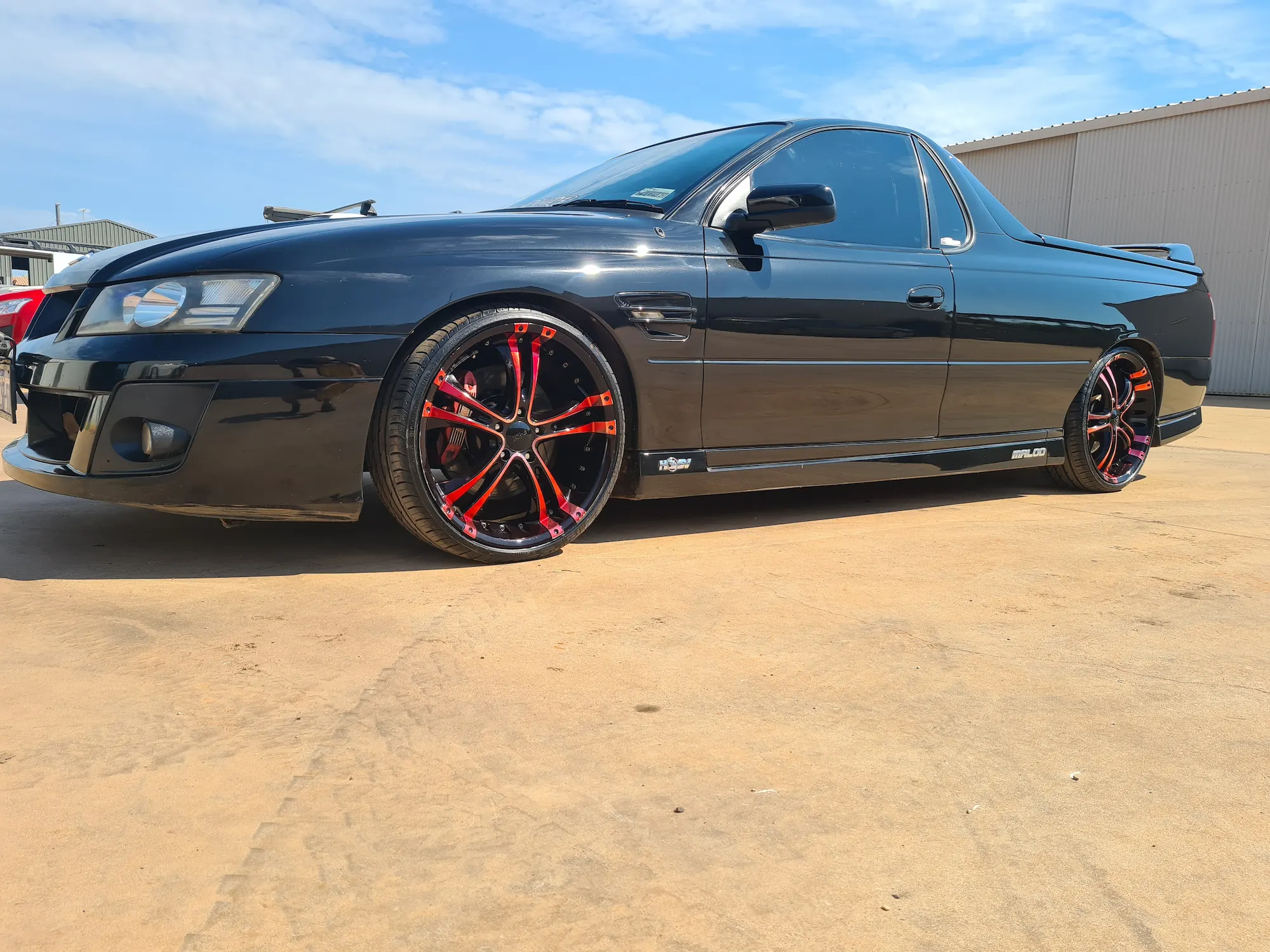Black HSV Maloo ute with mirror-finish paintwork and custom red-accented alloy wheels after detailing by Kimberley Auto Care