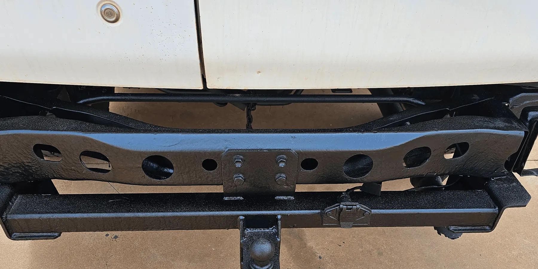 Rear cross member and tow bar coated in black rust-proof sealant after chassis rust proofing by Kimberley Auto Care