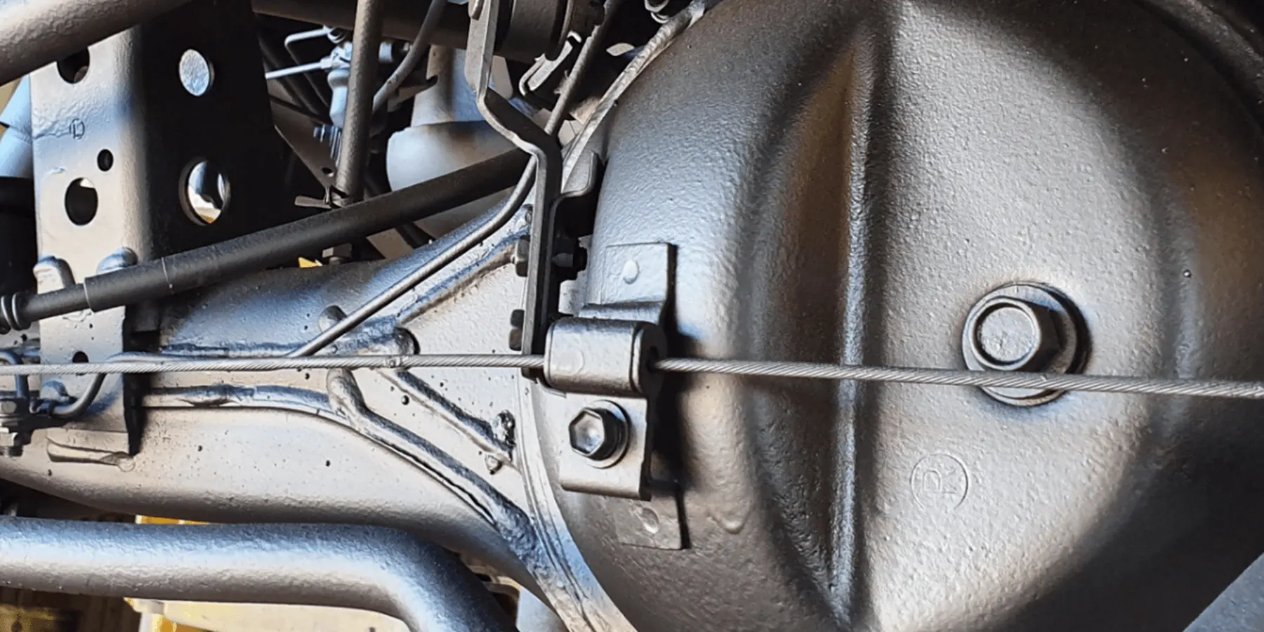 Rear differential housing and leaf spring suspension coated in satin-black rust-proof sealant after treatment by Kimberley Auto Care