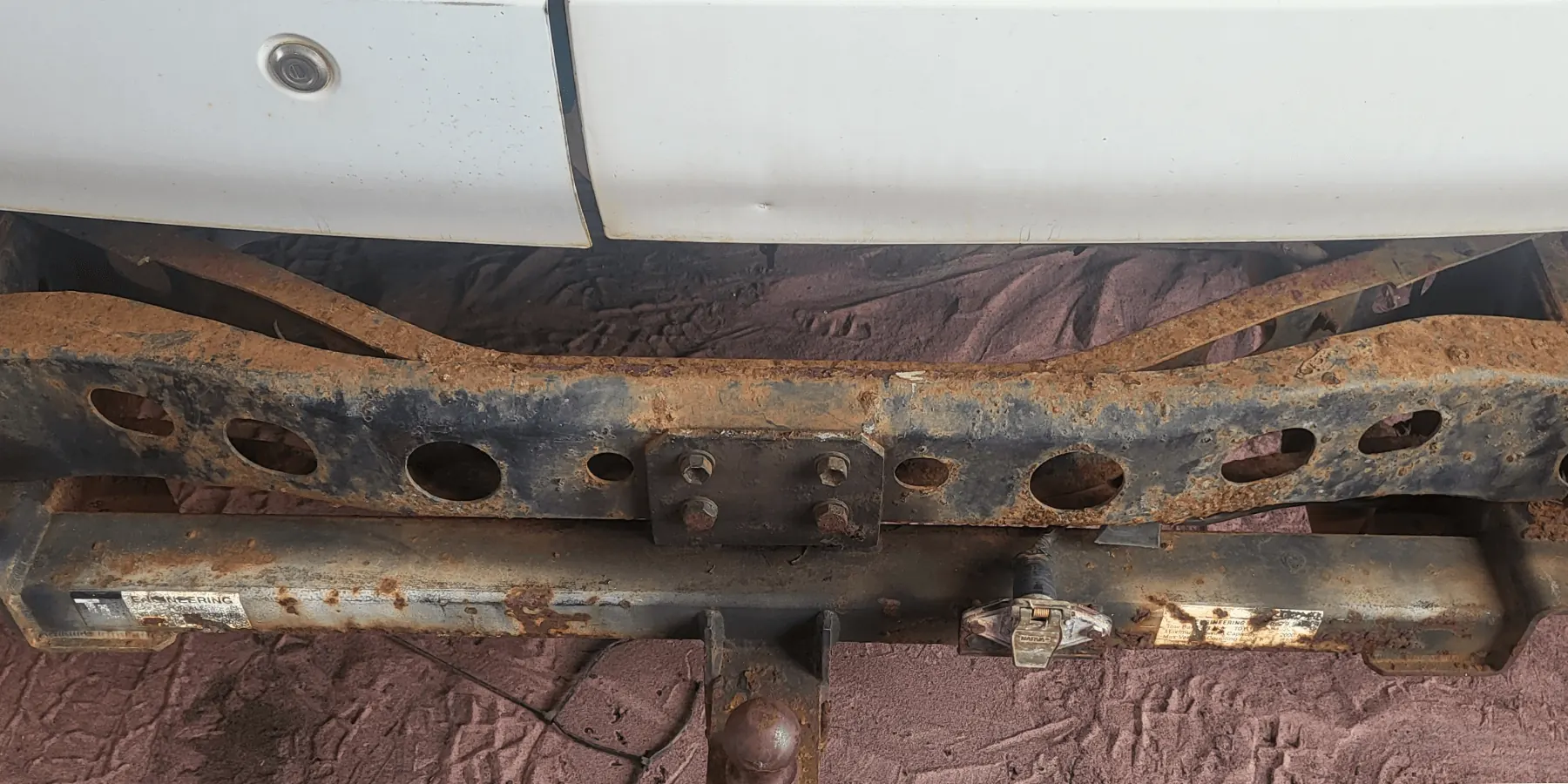 Heavily rusted rear cross member and tow bar caked in red Kimberley dirt before rust proofing by Kimberley Auto Care