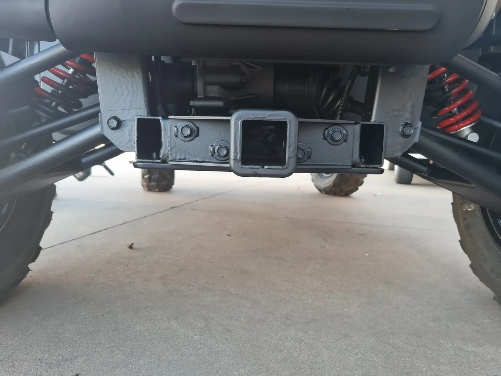 Rust-proofed rear hitch receiver and cross member with red coil spring suspension visible after undercarriage treatment by Kimberley Auto Care